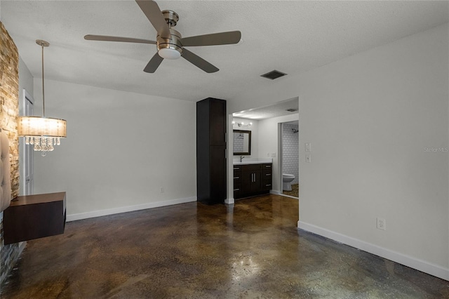 unfurnished living room featuring ceiling fan and a textured ceiling