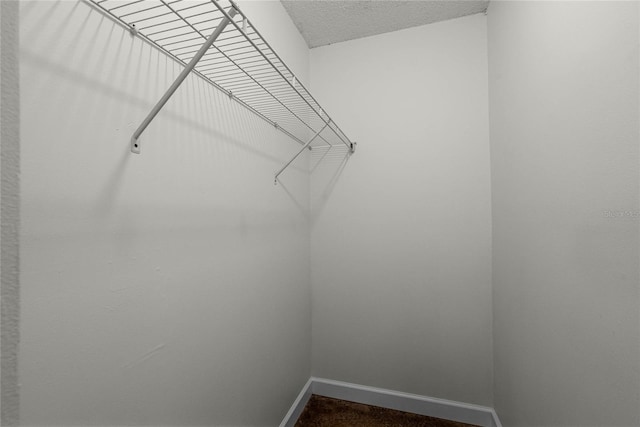 spacious closet featuring dark carpet