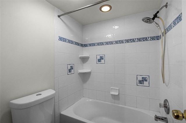 bathroom featuring toilet and tiled shower / bath