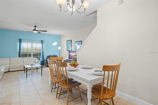 tiled dining area with ceiling fan with notable chandelier