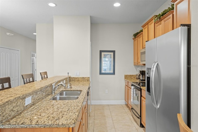 kitchen featuring sink, light stone counters, a kitchen bar, light tile patterned floors, and appliances with stainless steel finishes