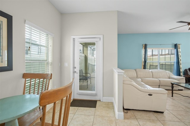 living room featuring a wealth of natural light, light tile patterned floors, and ceiling fan