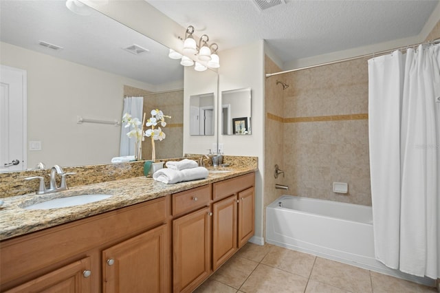 bathroom with tile patterned floors, a textured ceiling, vanity, and shower / tub combo