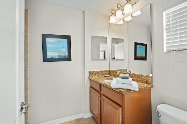 bathroom featuring tile patterned floors, vanity, a textured ceiling, and toilet