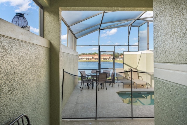 unfurnished sunroom featuring a swimming pool, a water view, and vaulted ceiling