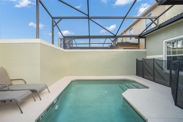 view of pool with glass enclosure and a patio