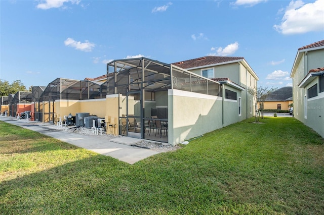 rear view of property featuring a lawn, a patio, and a lanai