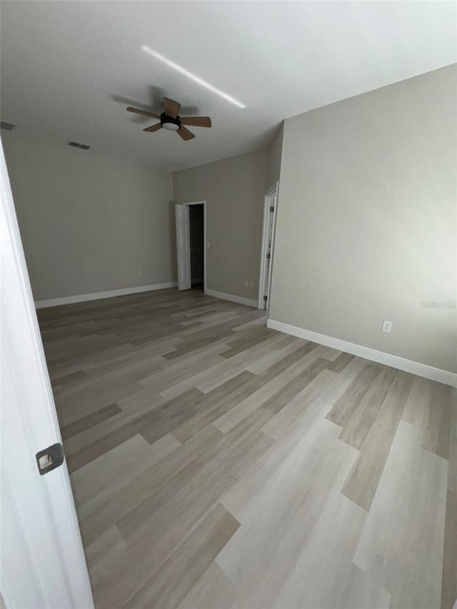 spare room featuring ceiling fan and light hardwood / wood-style flooring