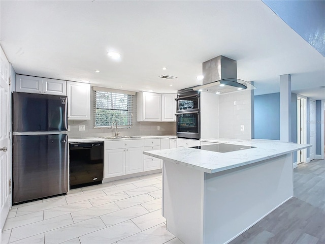 kitchen with white cabinets, island exhaust hood, kitchen peninsula, decorative backsplash, and black appliances