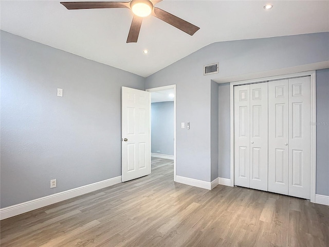 unfurnished bedroom featuring lofted ceiling, a closet, ceiling fan, and light hardwood / wood-style floors