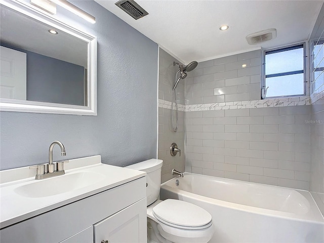 full bathroom featuring toilet, tiled shower / bath, and vanity