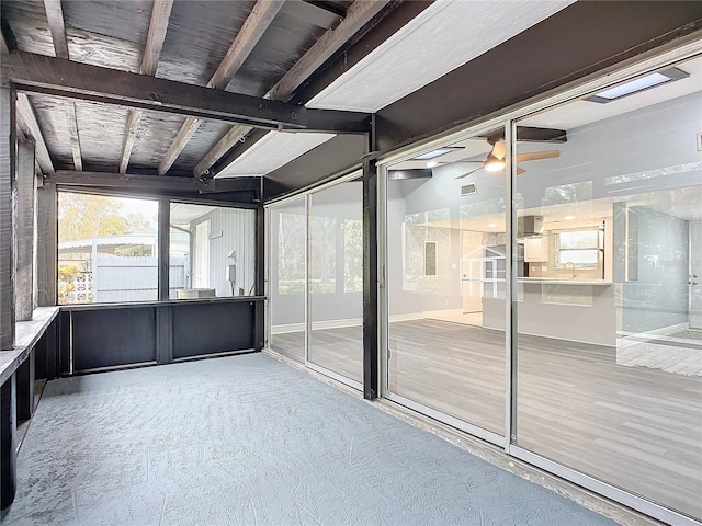 unfurnished sunroom with wooden ceiling, ceiling fan, and beamed ceiling