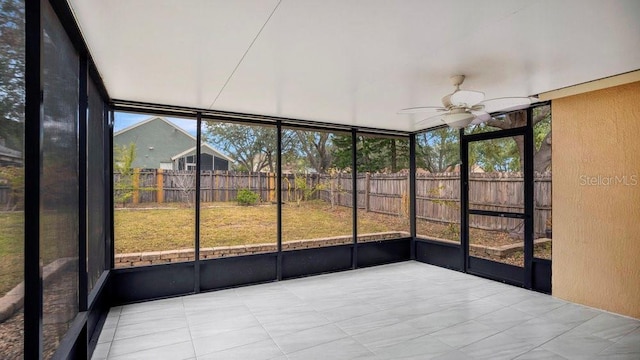 unfurnished sunroom featuring ceiling fan