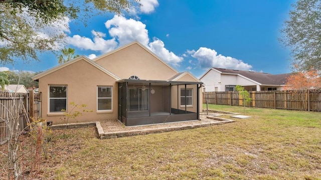 rear view of property featuring a sunroom and a yard