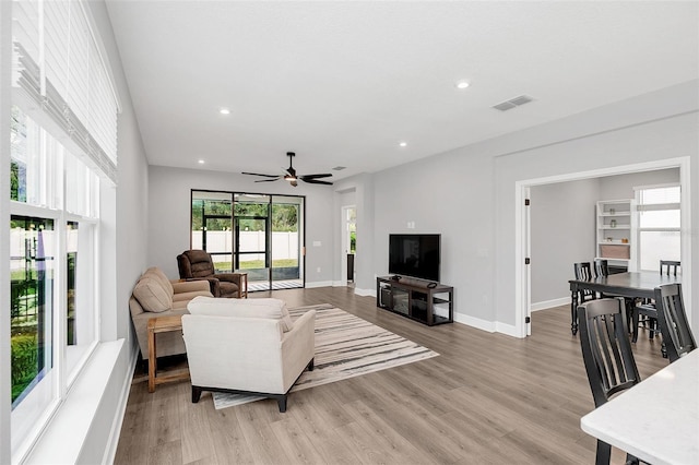 living room with light wood-type flooring and ceiling fan