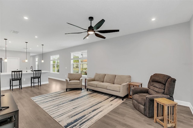 living room featuring light wood-type flooring and ceiling fan