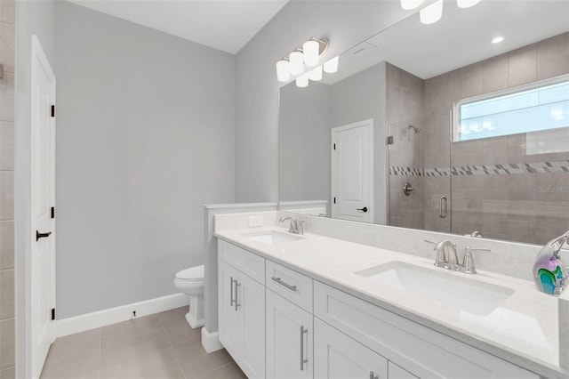 bathroom featuring toilet, a shower with shower door, tile patterned floors, and vanity