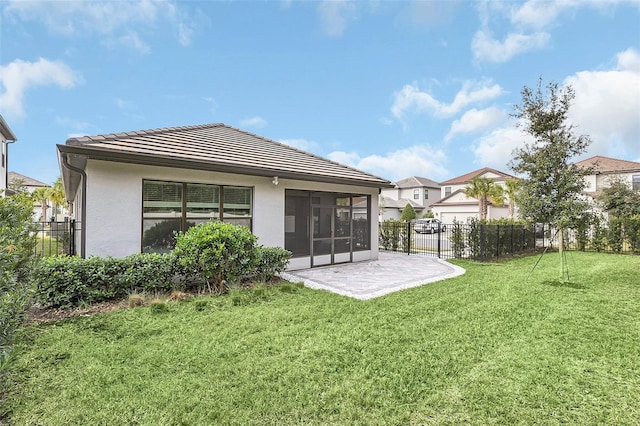 back of property featuring a sunroom, a patio area, and a yard