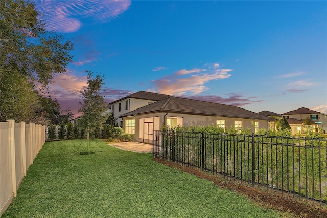 yard at dusk with a patio area