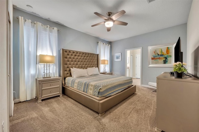 bedroom featuring ensuite bathroom, ceiling fan, and light colored carpet