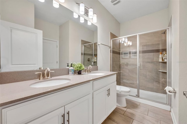 bathroom with toilet, a shower with shower door, tile patterned floors, and vanity