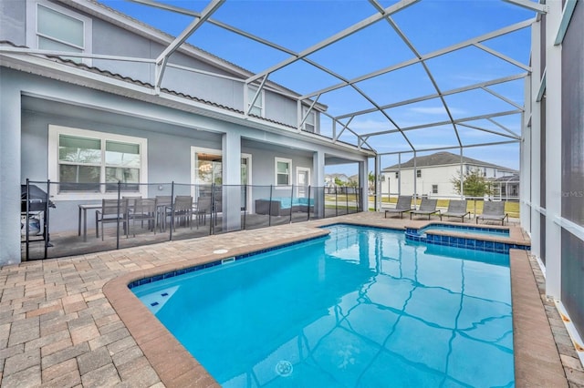 view of swimming pool featuring glass enclosure, an in ground hot tub, and a patio area