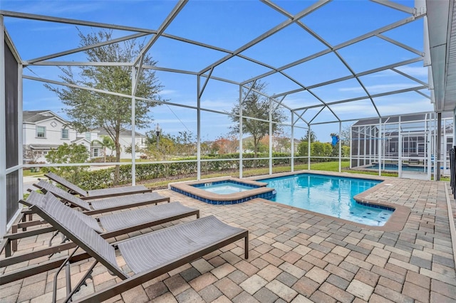 view of pool featuring a lanai, a patio area, and an in ground hot tub