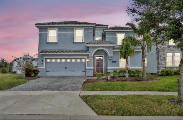 view of front of house with a garage and a yard