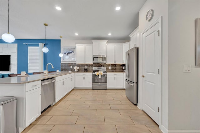 kitchen with stainless steel appliances, sink, white cabinetry, decorative light fixtures, and tasteful backsplash