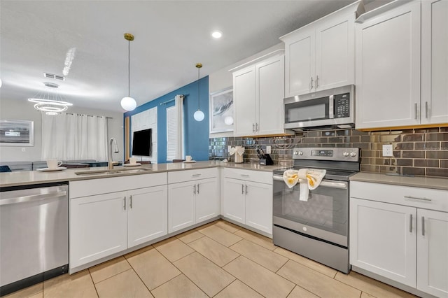 kitchen with stainless steel appliances, hanging light fixtures, decorative backsplash, white cabinets, and sink