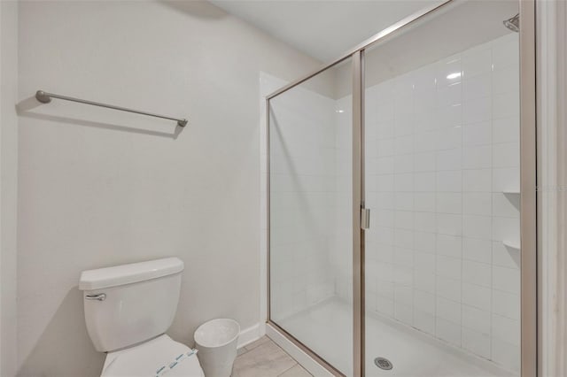 bathroom featuring toilet, walk in shower, and tile patterned flooring