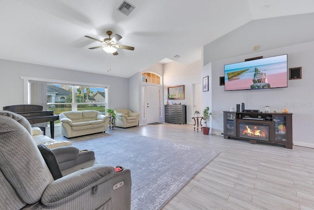 living room featuring vaulted ceiling, ceiling fan, and light hardwood / wood-style flooring