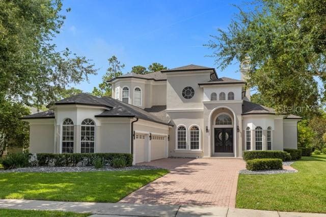 mediterranean / spanish-style home with a front lawn and a garage