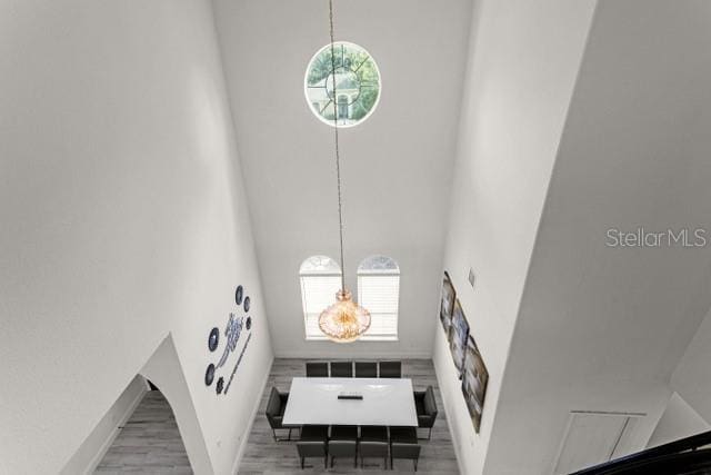 staircase featuring hardwood / wood-style flooring and a high ceiling