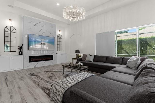 living room featuring hardwood / wood-style floors, a notable chandelier, and a tray ceiling