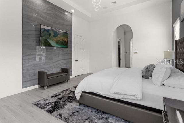 bedroom featuring a tray ceiling and hardwood / wood-style flooring