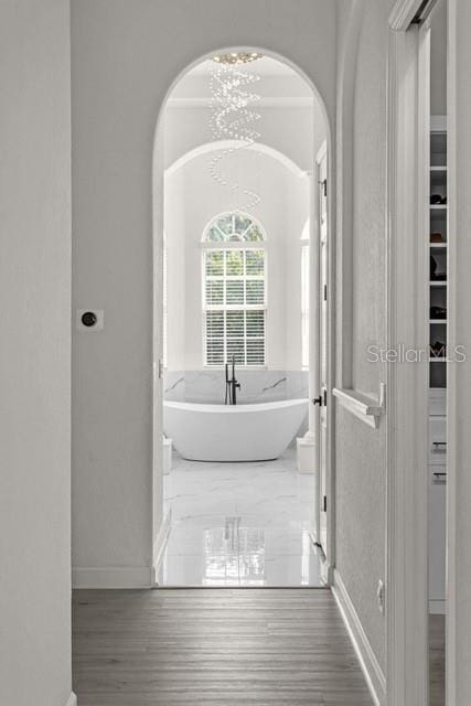 bathroom with a tub to relax in and wood-type flooring