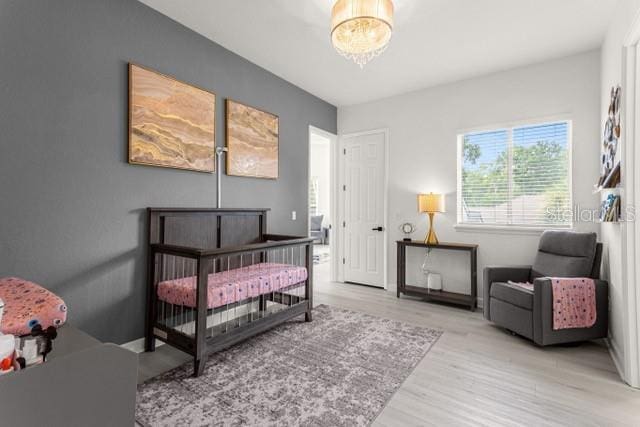 bedroom with a chandelier and light hardwood / wood-style floors