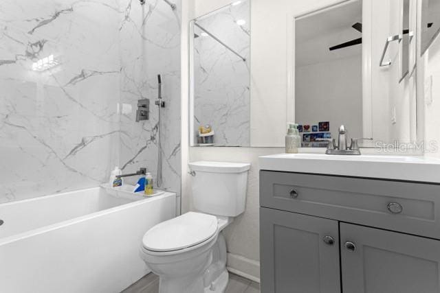 full bathroom with vanity, tiled shower / bath combo, and toilet