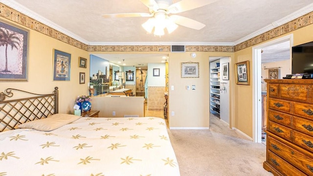 carpeted bedroom featuring a textured ceiling, ceiling fan, ornamental molding, and a closet