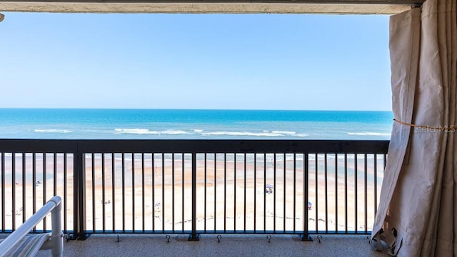 balcony featuring a beach view and a water view