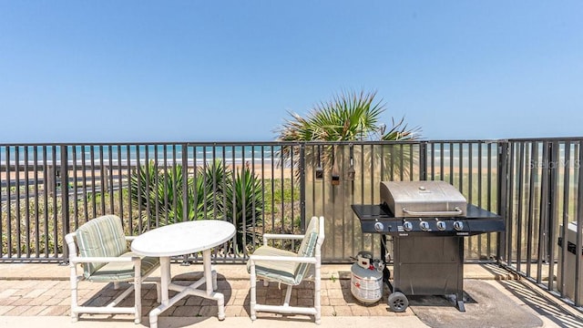 view of patio / terrace with area for grilling, a view of the beach, and a water view