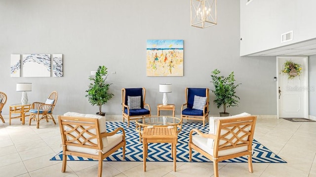 living area with a towering ceiling, a notable chandelier, and light tile patterned floors