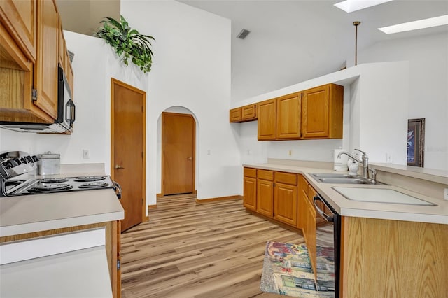 kitchen with black dishwasher, a skylight, sink, range with electric stovetop, and high vaulted ceiling