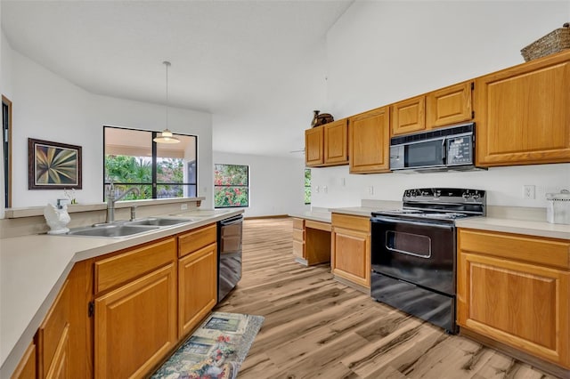 kitchen with decorative light fixtures, sink, black appliances, and light hardwood / wood-style floors