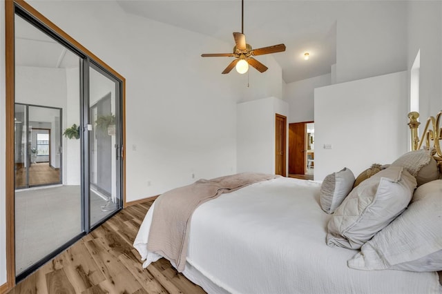 bedroom featuring ceiling fan, light hardwood / wood-style flooring, and high vaulted ceiling