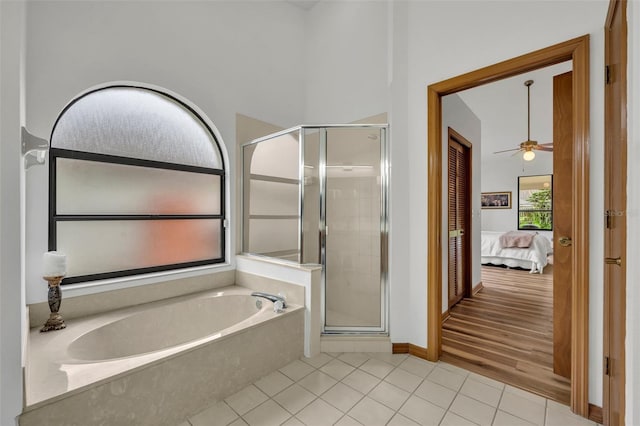 bathroom featuring plus walk in shower, ceiling fan, and tile patterned flooring