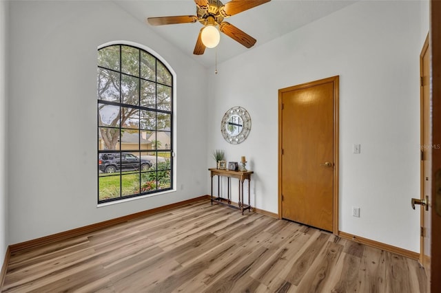 spare room with light wood-type flooring, ceiling fan, and lofted ceiling