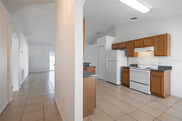 kitchen with white appliances, vaulted ceiling, a textured ceiling, and light tile patterned flooring