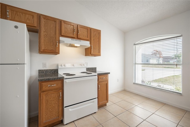 kitchen with lofted ceiling, light tile patterned floors, a textured ceiling, and white appliances